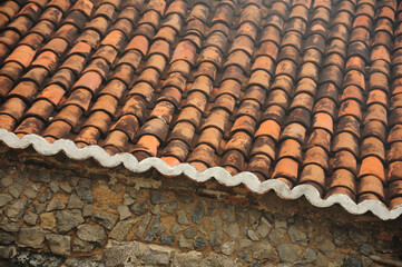 Rustic clay tile roof and stone wall, traditional architectural charm