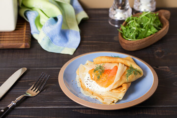 Pancake wrapped with cream cheese and smoked salmon. Crepe.