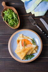 Pancake wrapped with cream cheese and smoked salmon. Crepe. High angle view