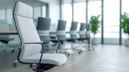 Modern office interior featuring a stylish ergonomic chair with a row of desks and greenery, showcasing a clean and professional environment