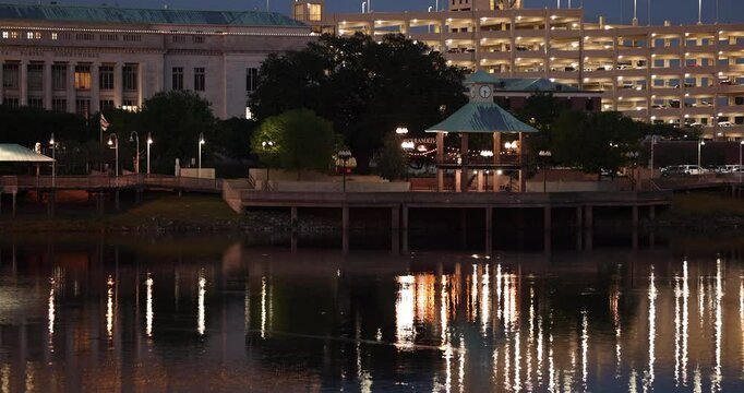 Monroe, Louisiana, USA - April 4, 2024: Evening lights shine on the historic buildings, skyline and river of downtown Monroe.