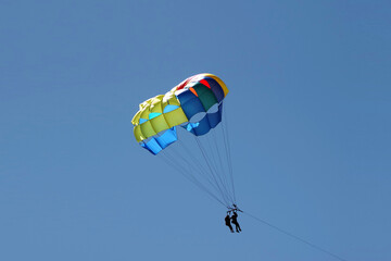 Two people parasailing high up in the sky