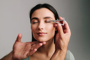 Obraz premium Blepharoplasty marking up. Plastic surgeon is measuring distance in between marking lines for well planned blepharoplasty. Using Castroviejo caliper to draw symmetrical contour for eyelid surgery.