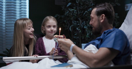 At the hospital, young father receives a surprise birthday visit from woman and daughter.