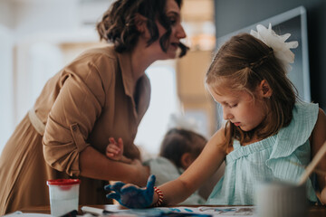 Fototapeta premium Mother helps her daughters during a fun and creative painting session at home, fostering creativity and bonding through art.