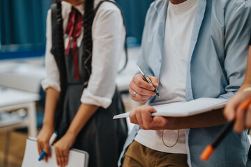 A diverse group of students actively involved in a collaborative study session at school. They are taking notes and sharing ideas, promoting teamwork and learning.