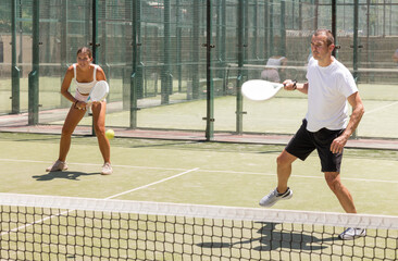 Obraz premium Sports woman and man playing padel on the tennis court