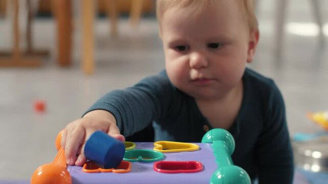 Cheerful toddler plays with a colorful shape sorting toy designed to enhance fine motor skills and cognitive development through engaging activities that stimulate learning