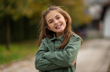 Portrait of a happy child girl outside looking at camera and smiling.