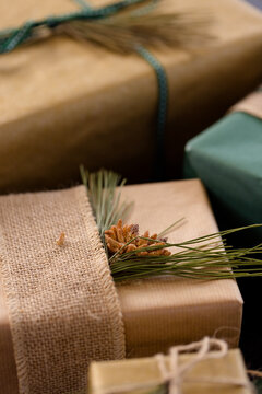 Rustic Christmas gifts wrapped with burlap and pine sprigs, creating festive charm, at home