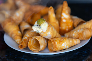 Traditional conical straws filled with mayonnaise, olives and parsley