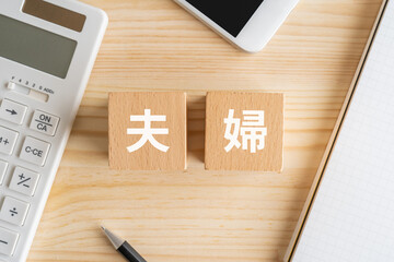 夫婦の文字が入ったブロック、電卓、スマホ