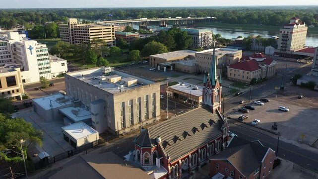Monroe, Louisiana, USA - April 4, 2024: Afternoon sunlight shines on the historic buildings and church in the skyline of downtown Monroe.