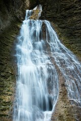 Obraz premium Cascading Waterfall in a Rocky Landscape