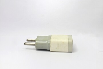 A close-up of a white, slightly dirty electrical wall charger with two metal prongs. The charger is isolated against a white background.