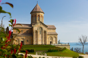 Obraz premium Impressive building of new Cathedral of Agia Nina at Bodbe Convent in foothills of Caucasus Mountains on sunny spring day, Kakheti, Georgia