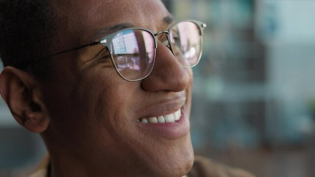 Close up face happy African American man male glasses student study looking contemplation think smile positive decisions aspirations high school teenager university learner teacher guy library ethnic
