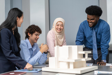 Architects engineers collaborating on building design project in modern office, diverse team of professionals female muslim architect and male engineers discussing architectural model of structure
