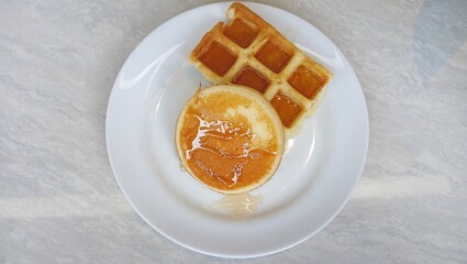 Waffles with honey sauce on a white plate. top of view,
