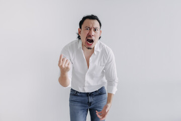 Angry face of long hair Asian man bun in white shirt and jean stand on white.