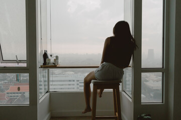 Lonely asian woman sitting alone looking out thoughtful of life.