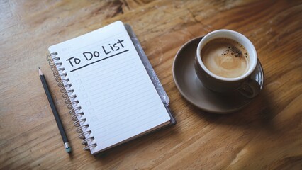 A to-do list, a pencil, and a cup of coffee on a wooden table.