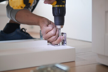 A handyman efficiently uses a power drill for furniture assembly and construction