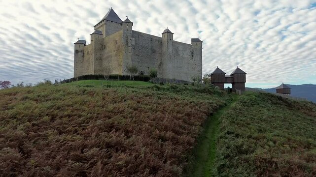 Aerial view on Mauvezin castle, a fortress with a medieval military architecture located in Occitania, France (dolly forward)