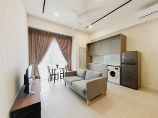 living room interior of a studio unit fully furnished with sofa, dining table, kitchen cabinet, tv, tv cabinet , curtain, washing machine and refrigerator