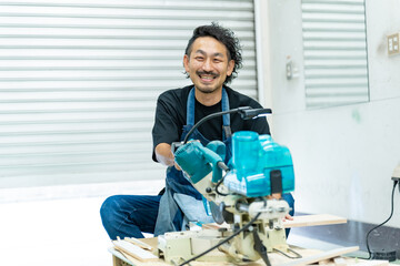 電動ノコギリを使う中年男性