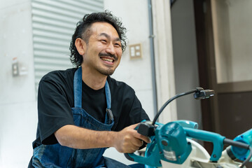 電動ノコギリを使う中年男性