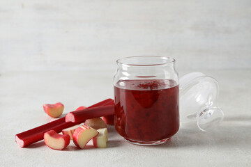 Rhubarb jelly in a jar with fresh rhubarb stems