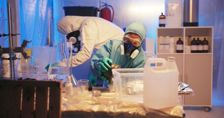 Drugs, people and hazmat with chemicals for production of illegal substances, powder and crystal meth. Teamwork, gas mask and bottle with compound mixture for cooking cocaine and manufacturing in lab