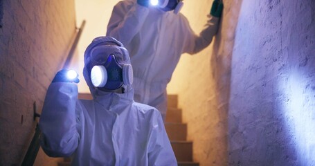 Hazmat, suit or people for safety walking with flashlight in basement for toxic spill or biohazard...