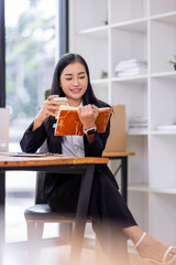 Portrait of Asian business woman holding coffee cup with work in workplace office Business documents money financial planning concept
