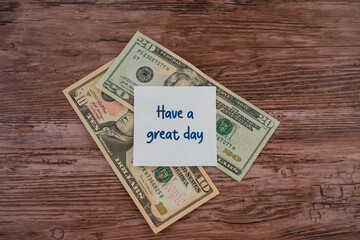 A stack of U.S. dollars with a note that says "Have a great day"