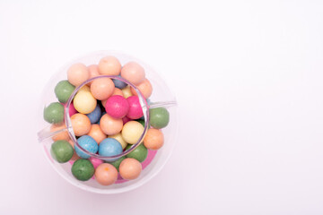 Pink gumball machine with a clear glass container full of colorful gumballs