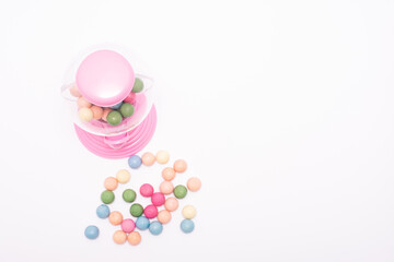 Pink gumball machine with a bunch of colorful gumballs in it