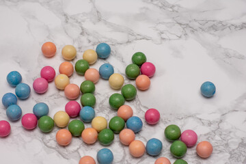 Bunch of colorful candy balls are scattered on a white background