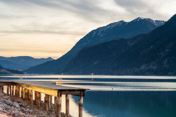 Early morning at the Achensee Tirol lake which is flat and quite and this cause a beautiful reflection of the water in a panoramic style