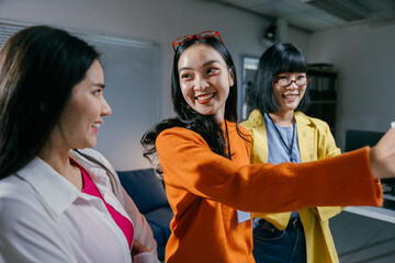 Three asian businesswomen in a bright office, deeply engaged in a lively discussion about a...