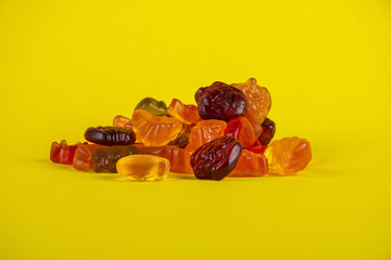 Assorted gummy candies, Juicy colorful jelly sweets. Gummy candies on yellow background