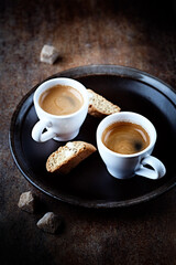 Cantuccini (Italian cookie) and Two Cups Of Coffee on rustic stone background. Copy space.	