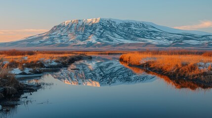 Obraz premium A snow-capped mountain reflects in a calm river. AI.
