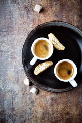 Cantuccini (Italian cookie) and Two Cups Of Coffee on rustic stone background. Top view. Copy space.	