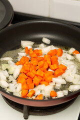 Finely chopped onions and fresh carrots are fried in butter, pate preparation