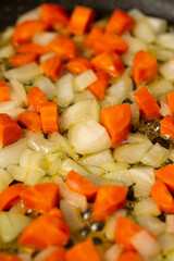 Finely chopped onions and fresh carrots are fried in butter, pate preparation