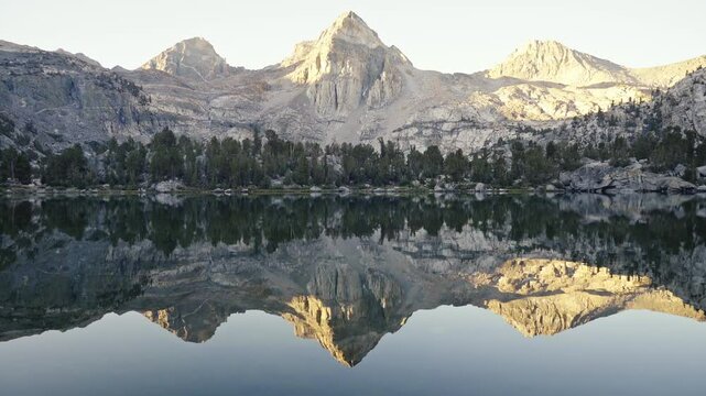 Rae Lakes reflecting towering mountains at sunrise on the John Muir Trail in California