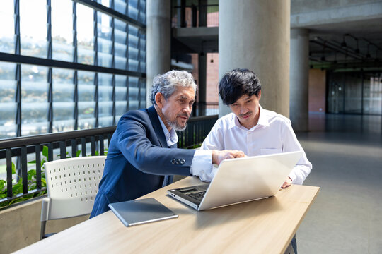 Asian senior professor is giving advice  to the college student on the research thesis while sitting in the university faculty for education, academic and business concept