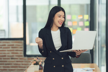 Businesswoman celebrating success on laptop